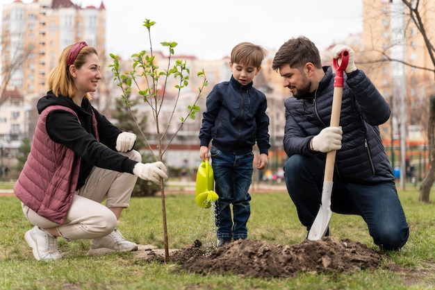 Foto gratuita familia plateando juntos un árbol