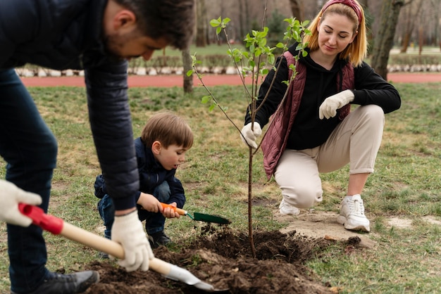 Familia plateando juntos un árbol