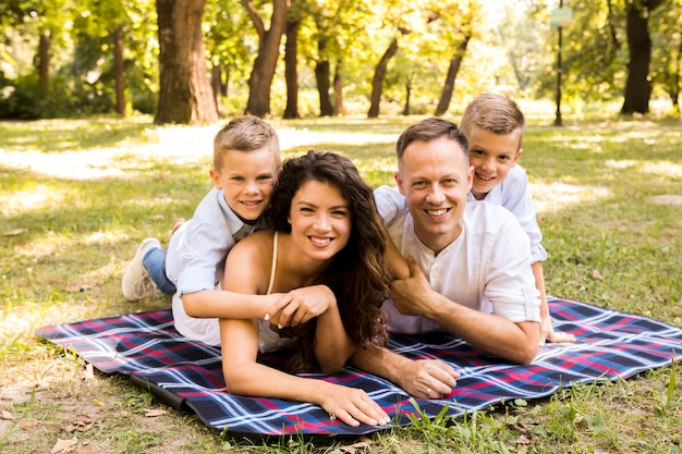 Familia posando juntos en una manta de picnic