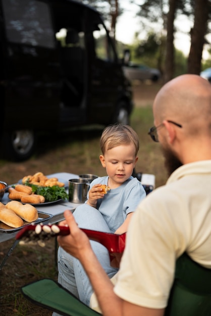 Familia preparando la cena mientras acampa