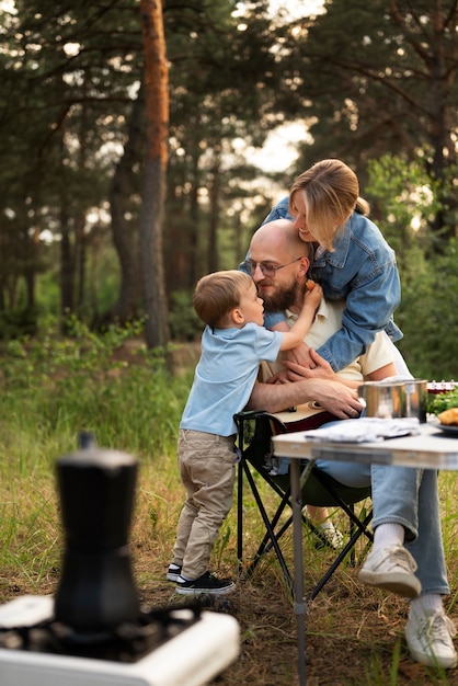 Familia preparando la cena mientras acampa