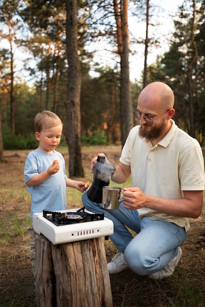 Familia preparando la cena mientras acampa