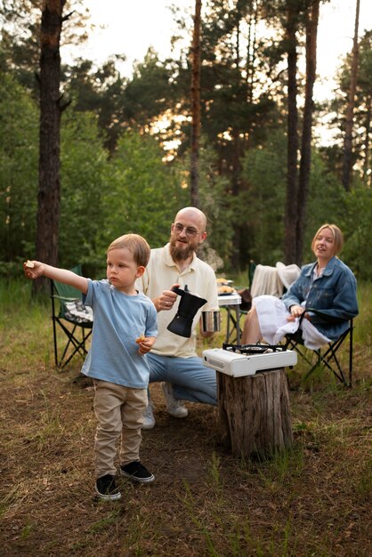 Familia preparando la cena mientras acampa