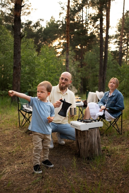 Familia preparando la cena mientras acampa