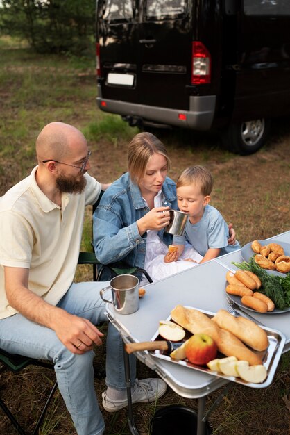 Familia preparando la cena mientras acampa