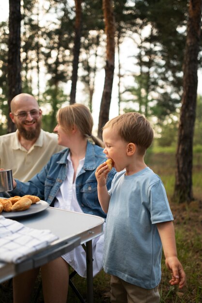 Familia preparando la cena mientras acampa