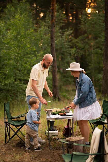 Familia preparando la cena mientras acampa