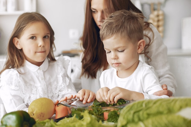 Foto gratuita familia preparando una ensalada en una cocina