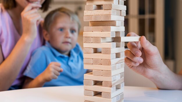 Familia de primer plano jugando jenga juntos