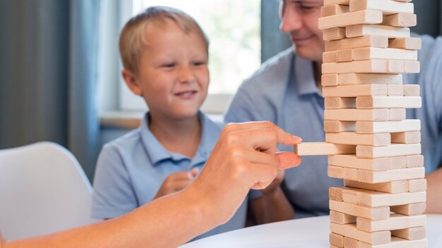 Familia de primer plano jugando jenga juntos