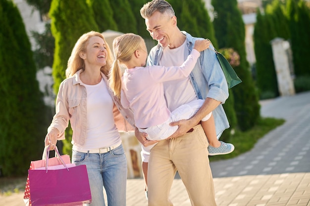 Familia que regresa de compras y lleva bolsas de la compra.