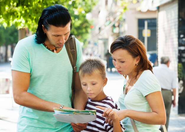 Familia que viaja mirando el mapa