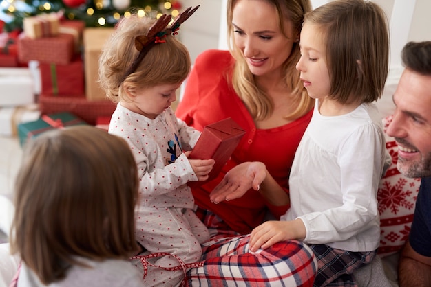 Familia con regalo de Navidad en la cama