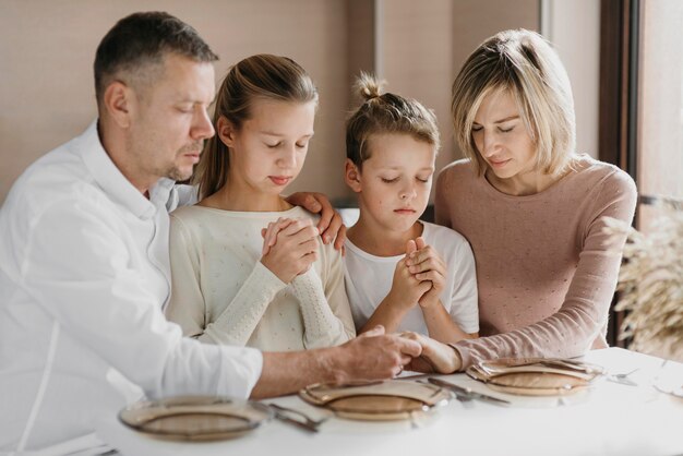 Familia rezando juntos antes de comer