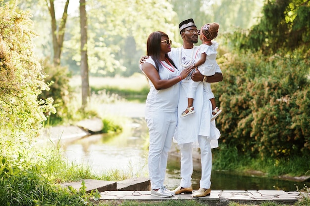 Familia rica afroamericana en ropa nacional nigeriana blanca