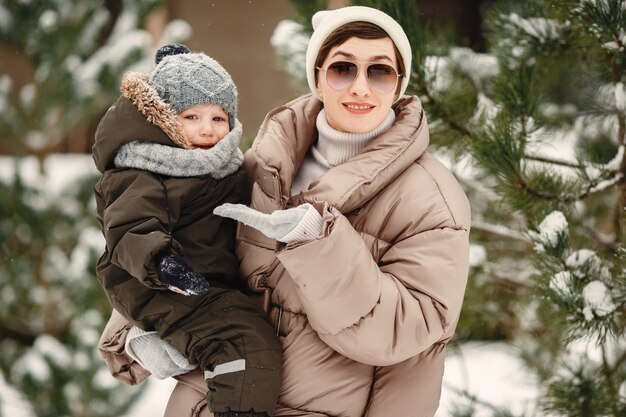 Familia en ropa de invierno de vacaciones en bosque nevado