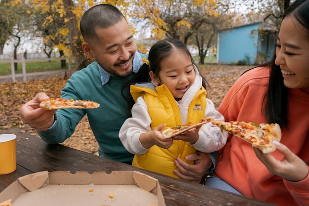 Foto gratuita familia con sabrosa pizza fuera de vista frontal