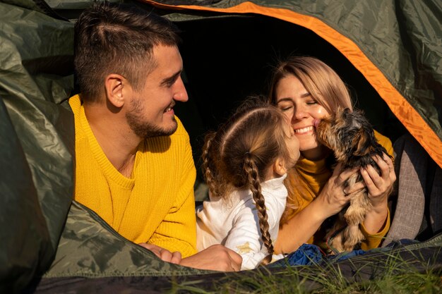 Familia sentada en la carpa con su perro