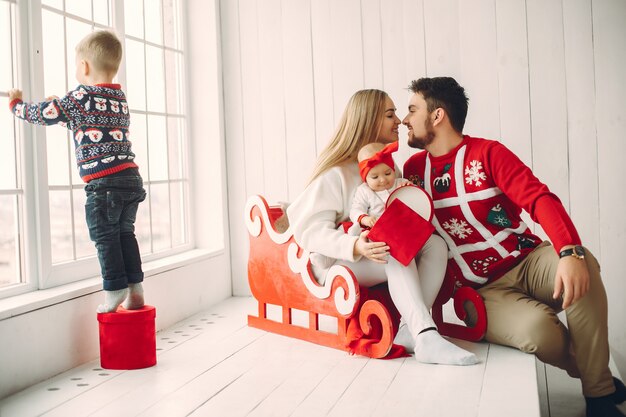 Familia sentada en casa con regalos de navidad