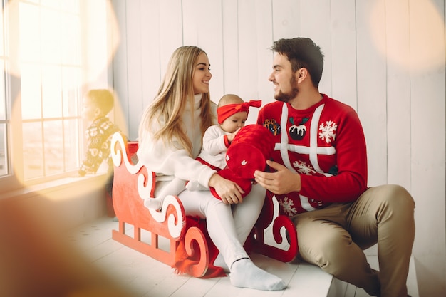 Familia sentada en casa con regalos de navidad