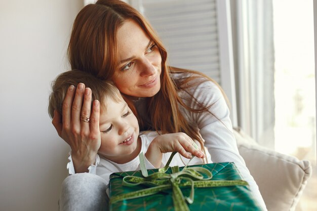 Familia sentada en casa con regalos