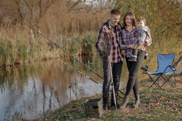 Familia sentada cerca del río en una mañana de pesca