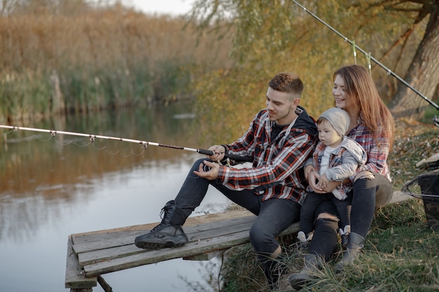 Familia sentada cerca del río en una mañana de pesca