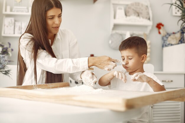 Familia sentada en una cocina y cocinar la masa para galletas