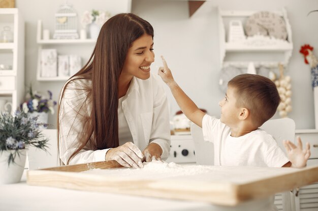 Familia sentada en una cocina y cocinar la masa para galletas