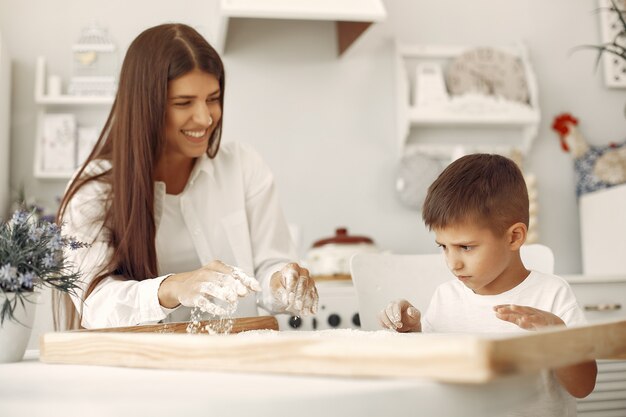 Familia sentada en una cocina y cocinar la masa para galletas