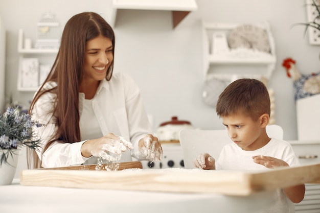 Familia sentada en una cocina y cocinar la masa para galletas