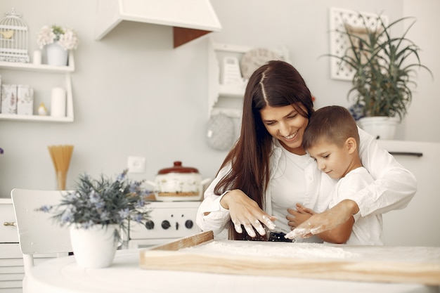 Familia sentada en una cocina y cocinar la masa para galletas