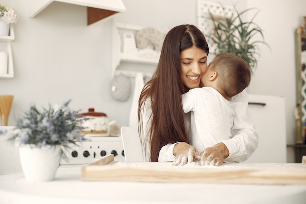 Familia sentada en una cocina y cocinar la masa para galletas