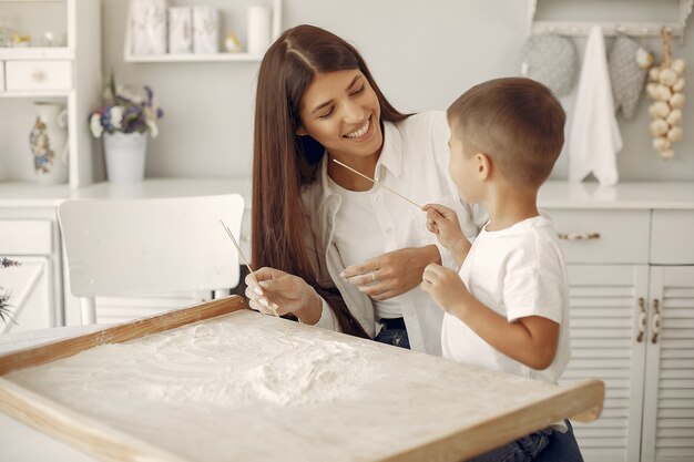 Familia sentada en una cocina y cocinar la masa para galletas