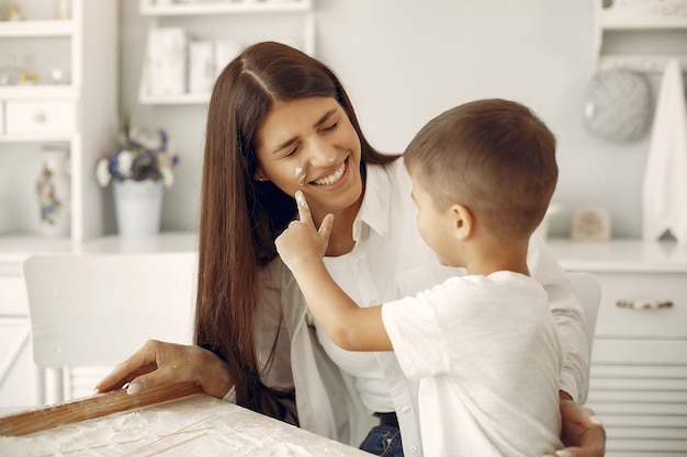 Familia sentada en una cocina y cocinar la masa para galletas