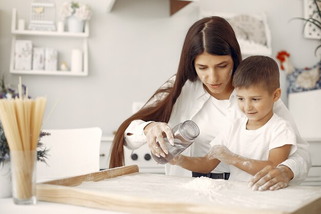 Familia sentada en una cocina y cocinar la masa para galletas