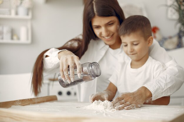 Familia sentada en una cocina y cocinar la masa para galletas