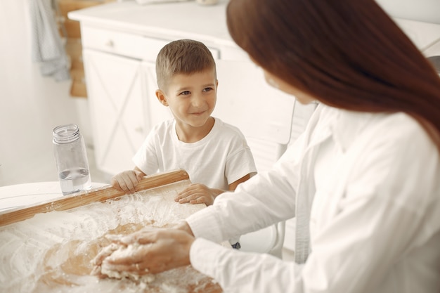 Familia sentada en una cocina y cocinar la masa para galletas