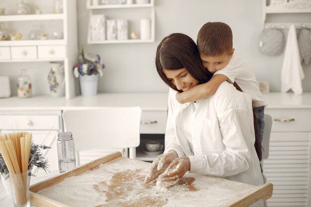 Familia sentada en una cocina y cocinar la masa para galletas