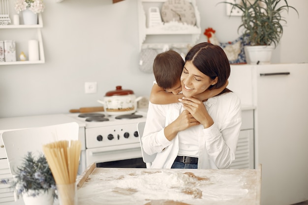 Familia sentada en una cocina y cocinar la masa para galletas