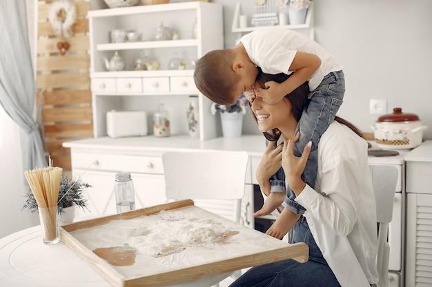 Familia sentada en una cocina y cocinar la masa para galletas