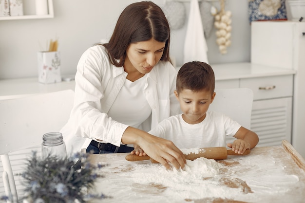 Familia sentada en una cocina y cocinar la masa para galletas