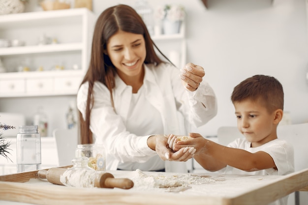 Familia sentada en una cocina y cocinar la masa para galletas