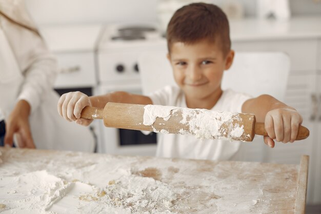 Familia sentada en una cocina y cocinar la masa para galletas