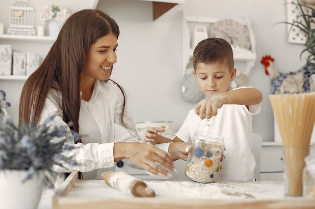 Familia sentada en una cocina y cocinar la masa para galletas