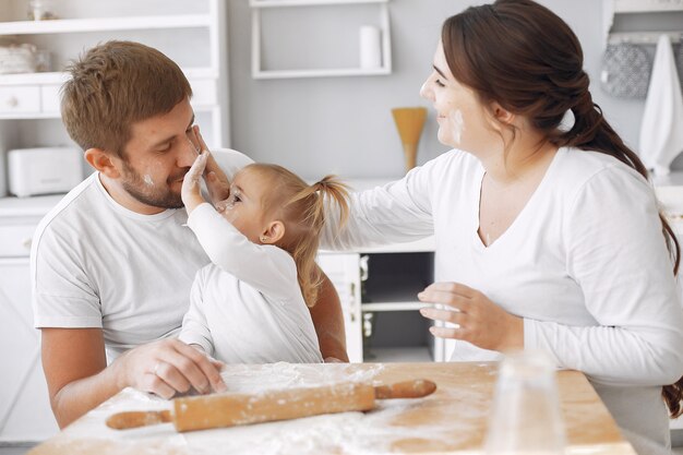 Familia sentada en una cocina y cocinar la masa para galletas