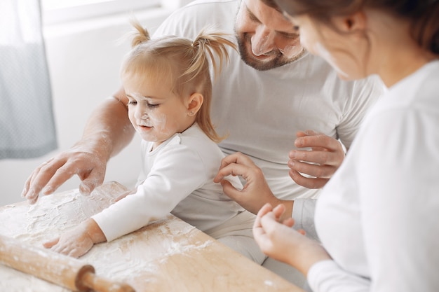 Familia sentada en una cocina y cocinar la masa para galletas