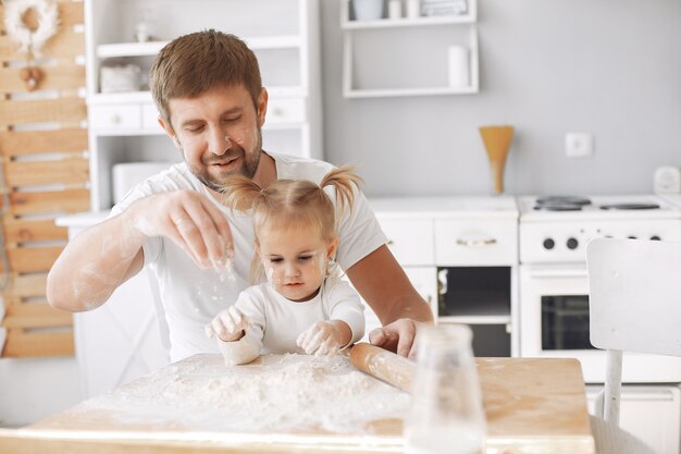 Familia sentada en una cocina y cocinar la masa para galletas