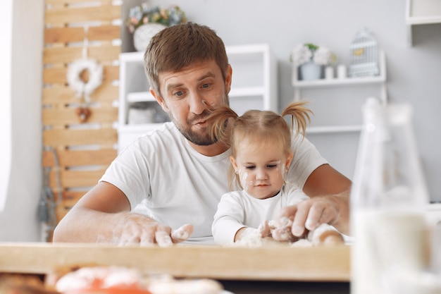 Familia sentada en una cocina y cocinar la masa para galletas