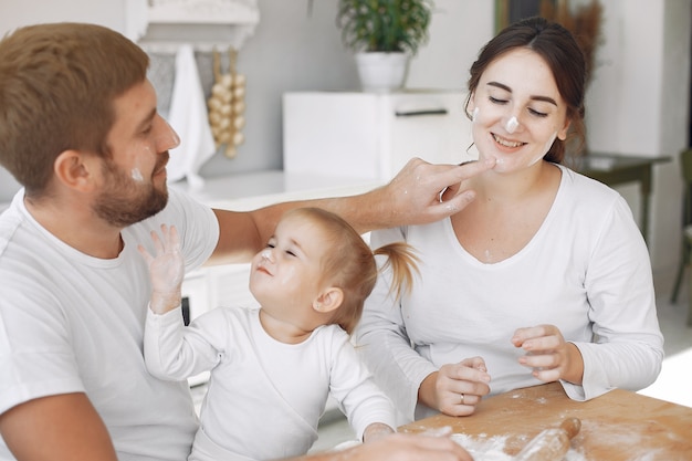 Familia sentada en una cocina y cocinar la masa para galletas